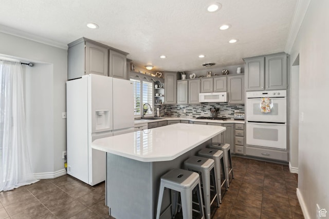 867 E 2850 N, North Ogden, UT 84414 - kitchen with gray cabinetry, a sink, a kitchen island, and white appliances