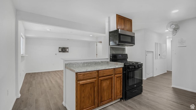 10674 S Pine Shadow Rd, South Jordan, UT 84009 - kitchen with light wood-style floors, recessed lighting, light countertops, stainless steel microwave, and black gas range oven