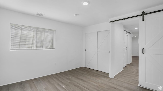 10674 S Pine Shadow Rd, South Jordan, UT 84009 - unfurnished bedroom with visible vents, a closet, wood finished floors, recessed lighting, and a barn door