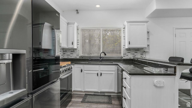10674 S Pine Shadow Rd, South Jordan, UT 84009 - kitchen with range with gas stovetop, a peninsula, stainless steel refrigerator with ice dispenser, white cabinetry, and a sink