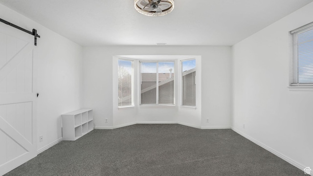 10674 S Pine Shadow Rd, South Jordan, UT 84009 - spare room with dark carpet, a barn door, and baseboards