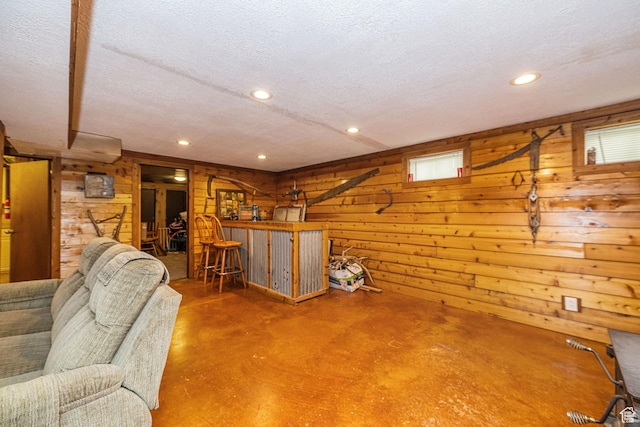 75 S 300 W, Morgan, UT 84050 - living area featuring a textured ceiling, wood walls, a bar, and finished concrete flooring