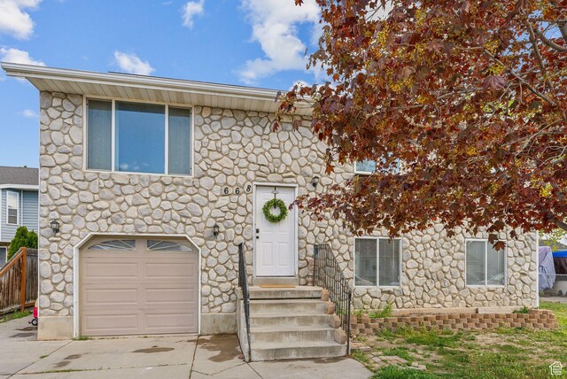 668 N 1370 W, Pleasant Grove, UT 84062 - view of front of house with an attached garage, driveway, and stone siding