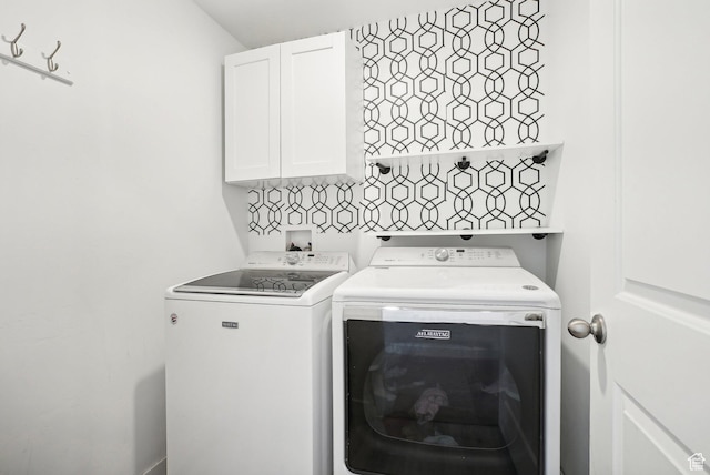 clothes washing area with cabinet space and independent washer and dryer