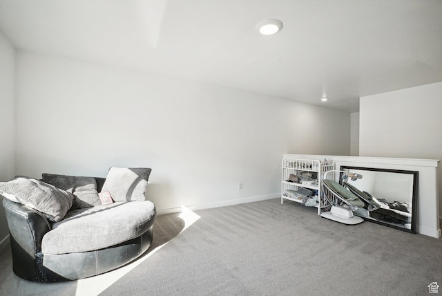 living area with carpet floors, baseboards, and an upstairs landing