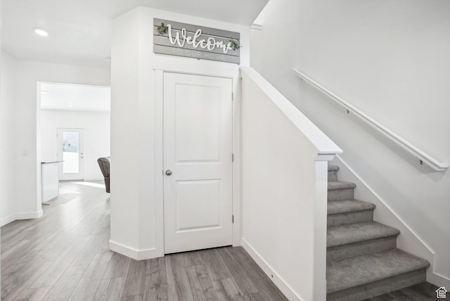 stairs with recessed lighting, baseboards, and wood finished floors