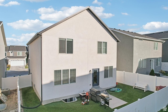 back of house with a lawn, a fenced backyard, and stucco siding