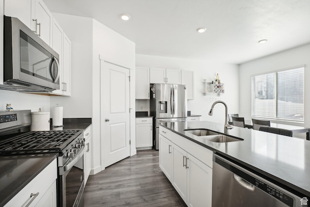 kitchen with a sink, dark countertops, white cabinets, and stainless steel appliances