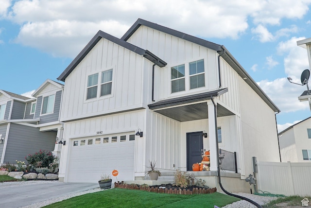 view of front of property with an attached garage, board and batten siding, fence, and driveway