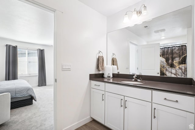 bathroom with vanity, baseboards, ensuite bathroom, and visible vents