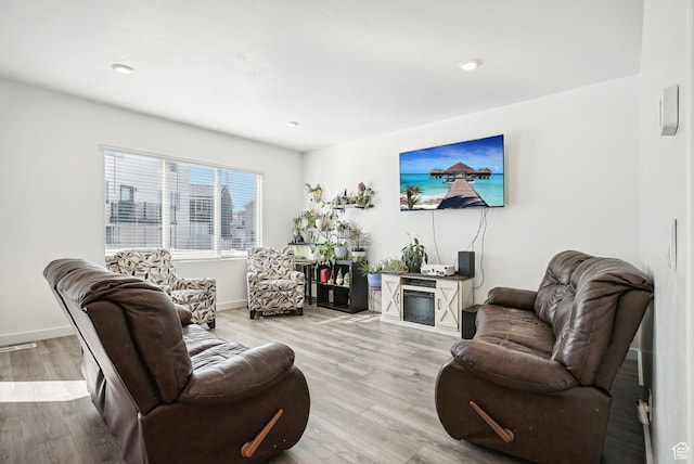 living area featuring baseboards, recessed lighting, wood finished floors, and visible vents