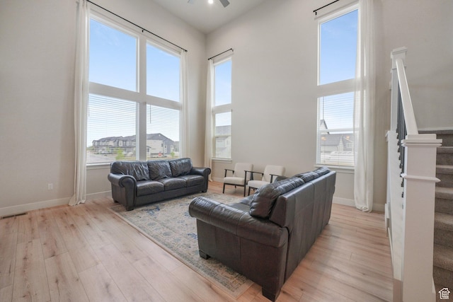 4576 W Sentry Dr, Riverton, UT 84096 - living room with stairway, a ceiling fan, plenty of natural light, light wood-type flooring, and a high ceiling