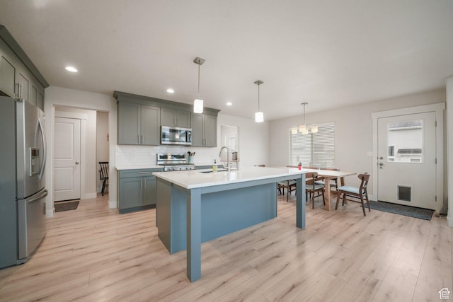 4576 W Sentry Dr, Riverton, UT 84096 - kitchen with appliances with stainless steel finishes, a sink, light wood-type flooring, light countertops, and tasteful backsplash