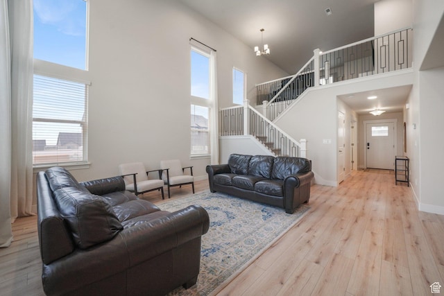 4576 W Sentry Dr, Riverton, UT 84096 - living area with stairs, a towering ceiling, wood finished floors, a chandelier, and baseboards