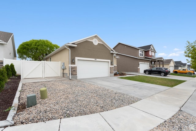 869 N Petro Dr W, Tooele, UT 84074 - view of front of home featuring stone siding, stucco siding, a gate, concrete driveway, and an attached garage