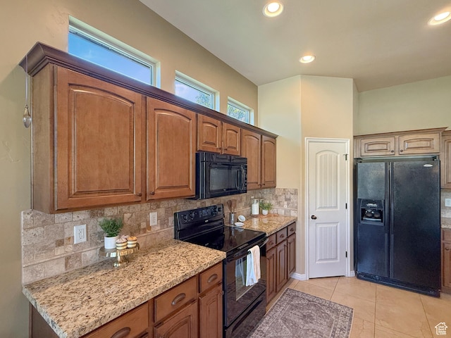 4116 N 800 W, Pleasant View, UT 84414 - kitchen featuring brown cabinets, light tile patterned flooring, light stone counters, decorative backsplash, and black appliances