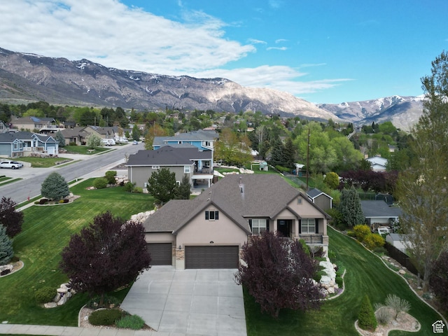exterior space with a garage, stucco siding, concrete driveway, a mountain view, and a residential view