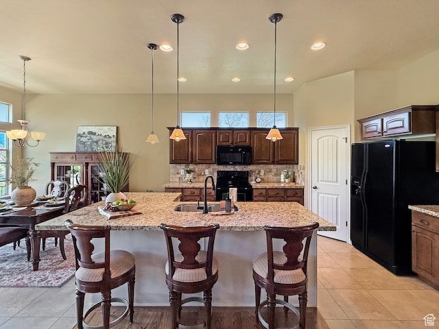 4116 N 800 W, Pleasant View, UT 84414 - kitchen featuring a sink, a kitchen breakfast bar, black appliances, and dark brown cabinets
