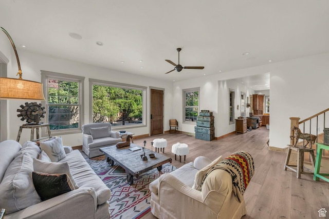 living room with ceiling fan, light wood-type flooring, stairway, baseboards, and recessed lighting