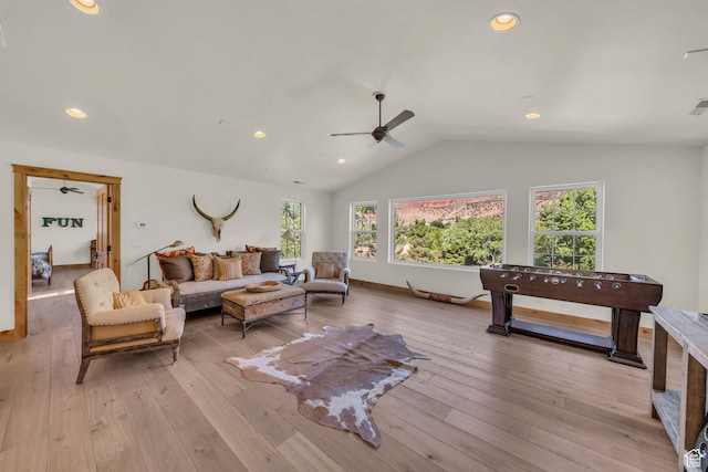 living room featuring plenty of natural light, a ceiling fan, light wood-style floors, and lofted ceiling