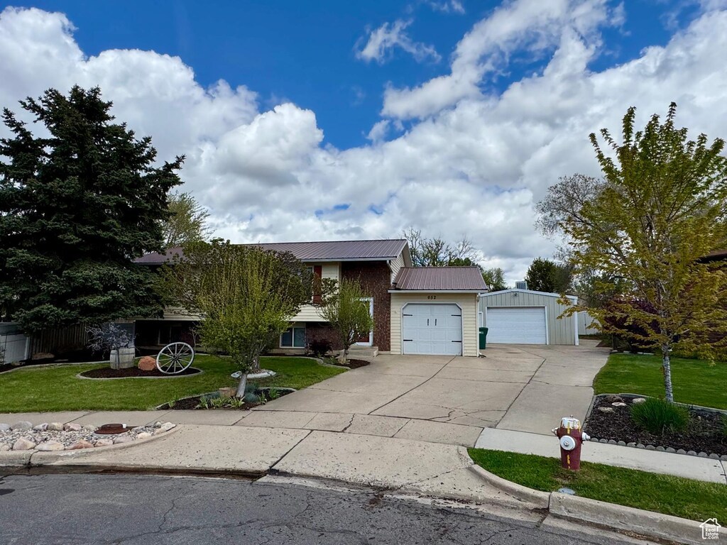 652 N 1250 W, Clearfield, UT 84015 - view of front facade with a garage, metal roof, driveway, and a front lawn