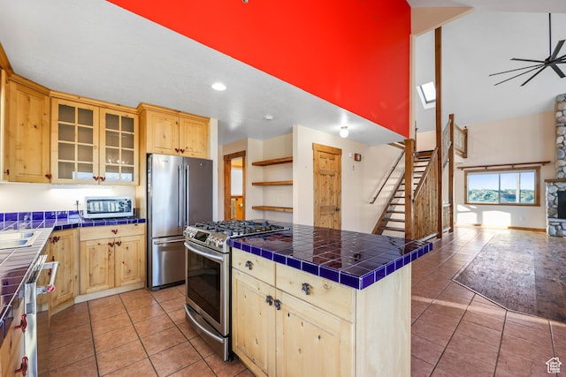 609 E 900 S, Stockton, UT 84071 - kitchen with light brown cabinetry, appliances with stainless steel finishes, tile countertops, and high vaulted ceiling
