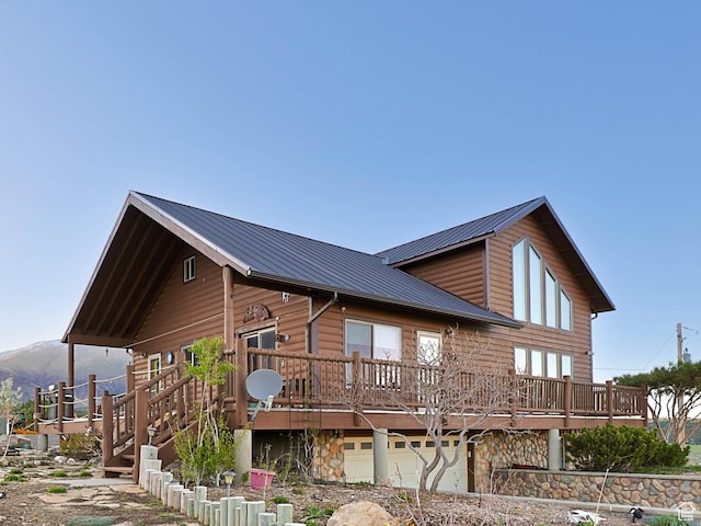 609 E 900 S, Stockton, UT 84071 - exterior space with a garage, a wooden deck, metal roof, and stone siding