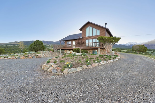 609 E 900 S, Stockton, UT 84071 - view of front facade with a deck with mountain view, driveway, stone siding, and metal roof