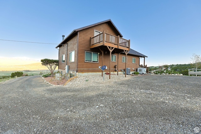 609 E 900 S, Stockton, UT 84071 - rear view of house featuring central AC unit, a balcony, and faux log siding