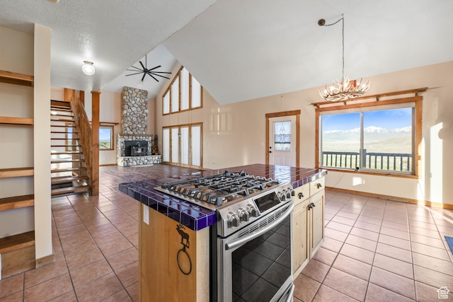 609 E 900 S, Stockton, UT 84071 - kitchen with tile countertops, light tile patterned flooring, stainless steel gas range oven, and a fireplace
