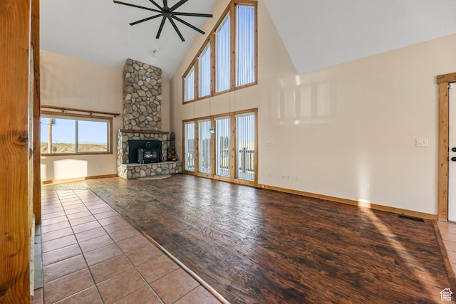 609 E 900 S, Stockton, UT 84071 - unfurnished living room featuring a healthy amount of sunlight, high vaulted ceiling, a ceiling fan, and a stone fireplace