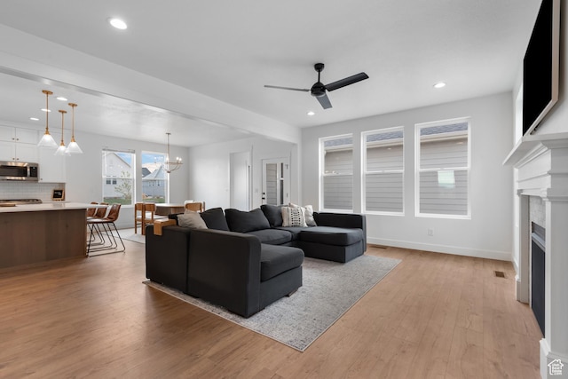 11254 S Bingham Rim Rd W, South Jordan, UT 84009 - living room with a ceiling fan, light wood-style flooring, a fireplace, recessed lighting, and a chandelier