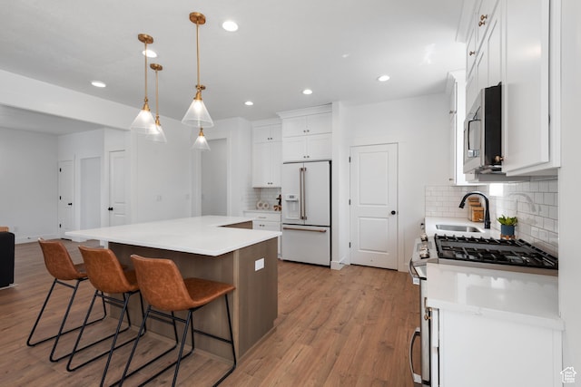 11254 S Bingham Rim Rd W, South Jordan, UT 84009 - kitchen with appliances with stainless steel finishes, a sink, backsplash, a center island, and white cabinets