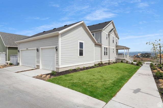 11254 S Bingham Rim Rd W, South Jordan, UT 84009 - view of side of home featuring a lawn, concrete driveway, a porch, board and batten siding, and an attached garage