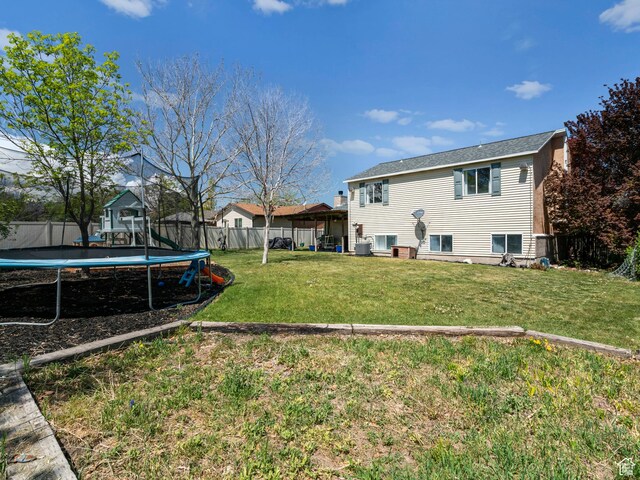 3855 W Elwood Way S, West Jordan, UT 84088 - back of property with a lawn, a trampoline, and fence