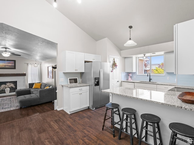 3855 W Elwood Way S, West Jordan, UT 84088 - kitchen featuring stainless steel fridge, a sink, a kitchen breakfast bar, white cabinetry, and vaulted ceiling