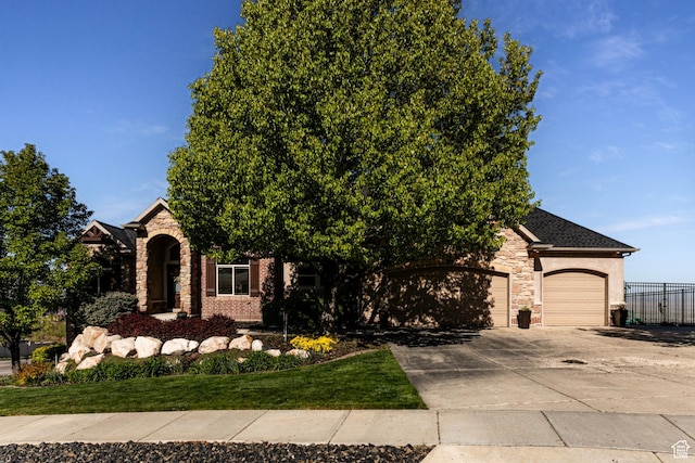 398 S Lofty Ln E, North Salt Lake, UT 84054 - obstructed view of property featuring fence, driveway, stone siding, and a garage