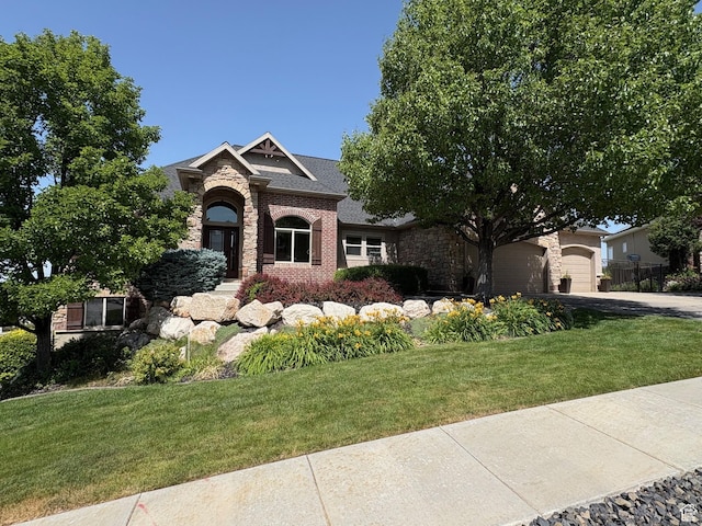 398 S Lofty Ln E, North Salt Lake, UT 84054 - view of front of property with stone siding, asphalt driveway, a front lawn, brick siding, and a garage
