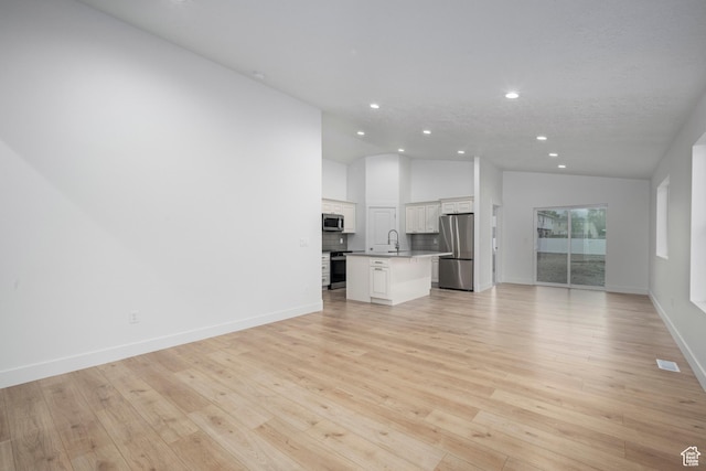 92 N 300 W, American Fork, UT 84003 - unfurnished living room featuring recessed lighting, a sink, light wood-type flooring, baseboards, and high vaulted ceiling