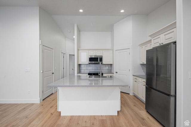 92 N 300 W, American Fork, UT 84003 - kitchen featuring appliances with stainless steel finishes, tasteful backsplash, light wood-type flooring, a kitchen island with sink, and recessed lighting