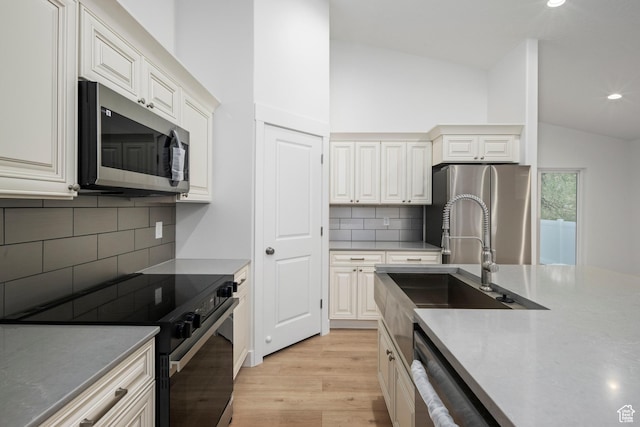 92 N 300 W, American Fork, UT 84003 - kitchen with appliances with stainless steel finishes, a sink, vaulted ceiling, light wood-type flooring, and recessed lighting