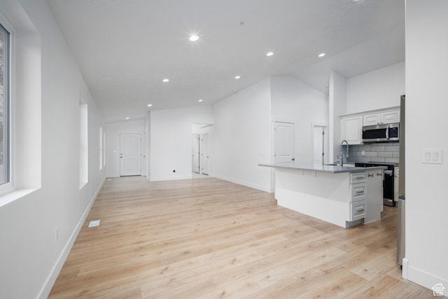 92 N 300 W, American Fork, UT 84003 - kitchen featuring stainless steel microwave, light wood-style flooring, tasteful backsplash, recessed lighting, and vaulted ceiling