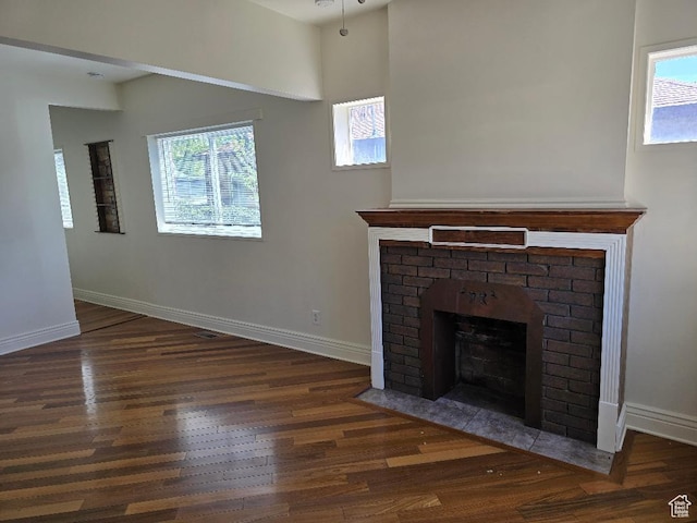 567 S 800 E, Salt Lake City, UT 84102 - unfurnished living room with healthy amount of natural light, wood finished floors, and a brick fireplace