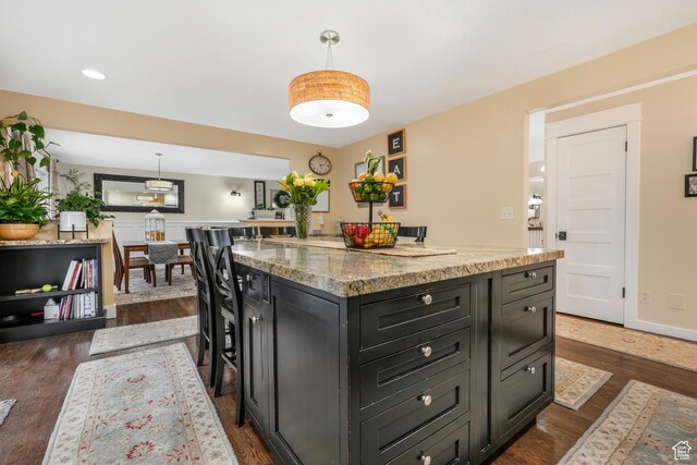 3273 E Bernada Dr, Salt Lake City, UT 84124 - kitchen with pendant lighting, light stone countertops, dark wood-style floors, a center island, and dark cabinets
