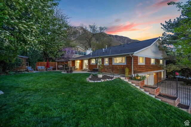 3273 E Bernada Dr, Salt Lake City, UT 84124 - back of house at dusk with a yard, fence, a mountain view, and a patio area