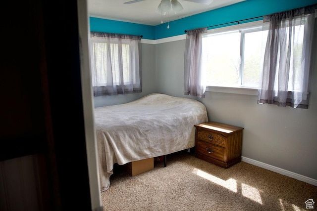 carpeted bedroom with baseboards and a ceiling fan