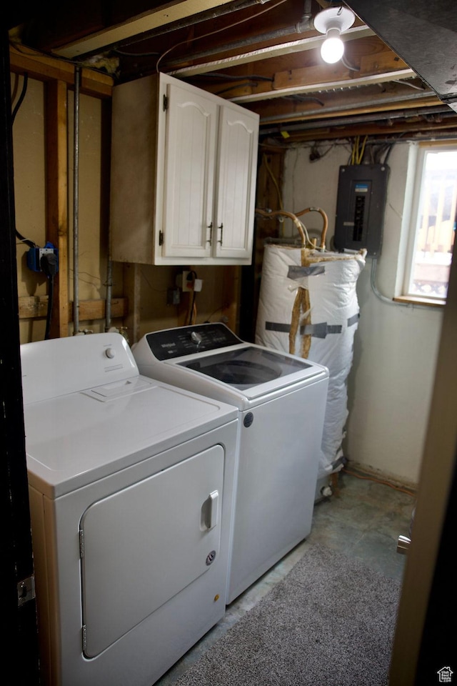 laundry room featuring water heater, electric panel, cabinet space, and independent washer and dryer