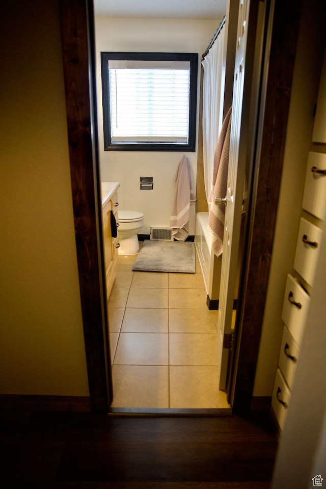 bathroom featuring vanity, toilet, tile patterned floors, baseboards, and visible vents