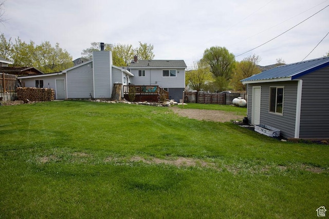 view of yard with a fenced backyard, an outbuilding, and a deck