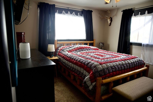 carpeted bedroom with freestanding refrigerator